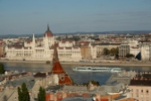 widok na czerwone dachówki Budy, monumentalny budynek parlamentu w Peszcie i barkę na Dunaju